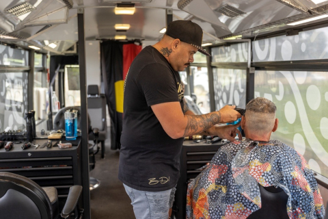 Brian Dowd, Walkabout Barber, giving a haircut and having mental and sexual health chat in the Barber Bus 