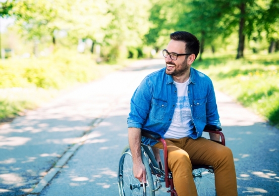 Man smiling in a wheelchair outdoors