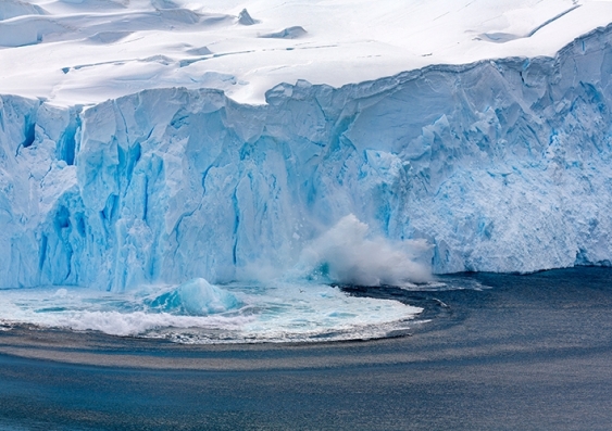 A chunk of the Antarctic ice sheet breaks off into the freezing water below