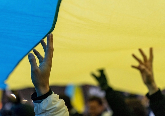 People march holding aloft a giant Ukranian flag