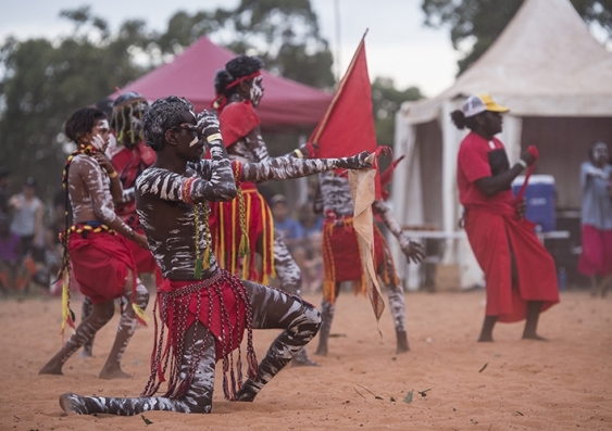 Indigenous Australians in tribal gear perform in a ceremony