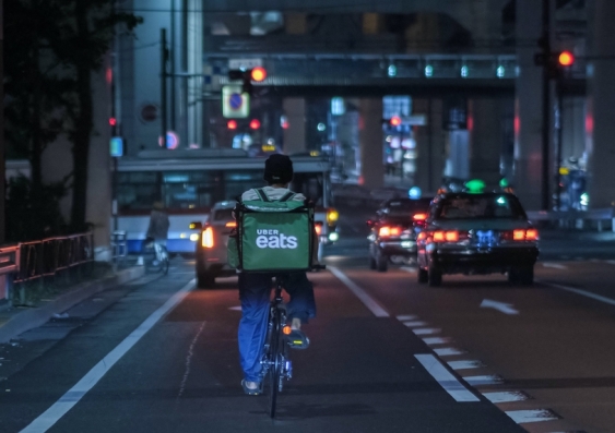 a delivery rider his bike on the road at night
