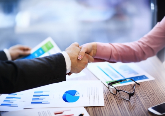 a handshake between two people signifying a business deal