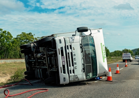 A truck rollover on a highway is attended by emergency services