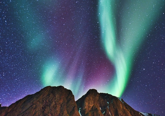 Aurora borealis above mountain peak
