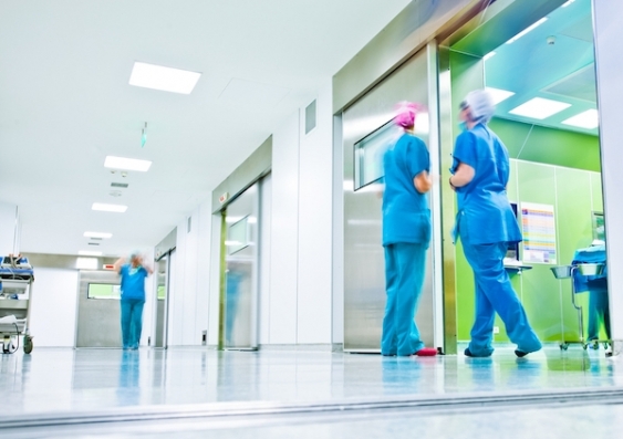 Healthcare workers walk in a hospital hallway