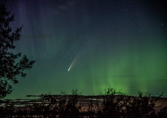 The green-headed Comet Neowise flying over a green aurora