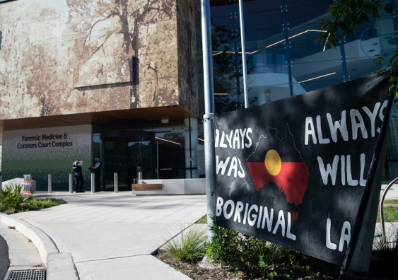 coronoers court with indigenous protest flag in foreground