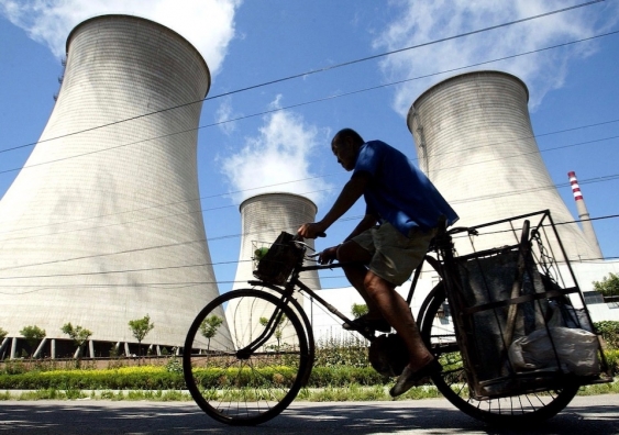 cyclist in front of cooling towers