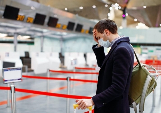 Man looking worried and wearing a mask at the airport