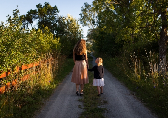 woman and little girl walking down a path
