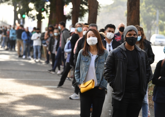 masked people waiting in line