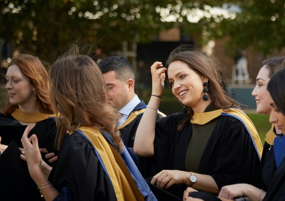 A smiling girl in a group of graduates