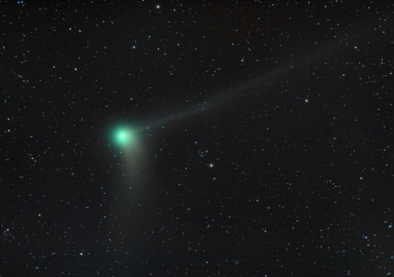 Green comet with two tails flying through space
