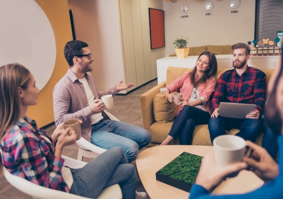 Group of casually dressed employees discuss ideas in the office