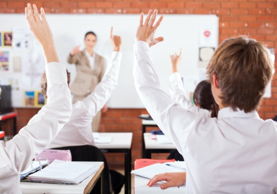 group of students arms up in classroom