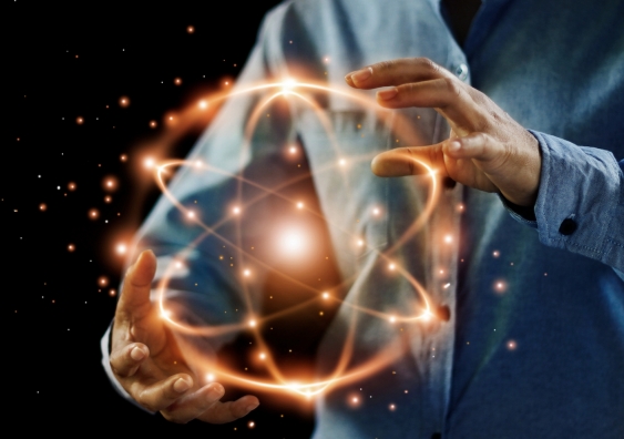illustration of a scientists hands holding golden atoms in motion