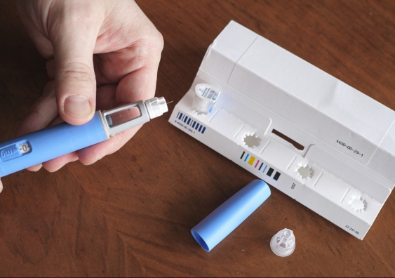 Obese man prepares Ozempic pen. Semaglutide treatment for type 2 diabetes.