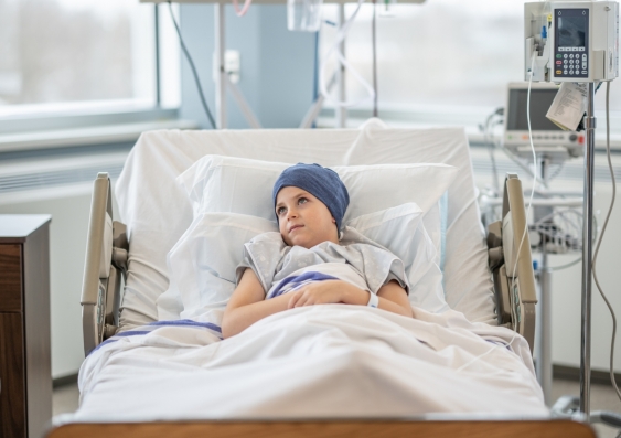 Childhood cancer patient in hospital bed. 