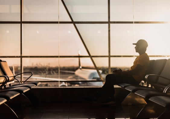 A person sitting on a chair waiting to board a plane.