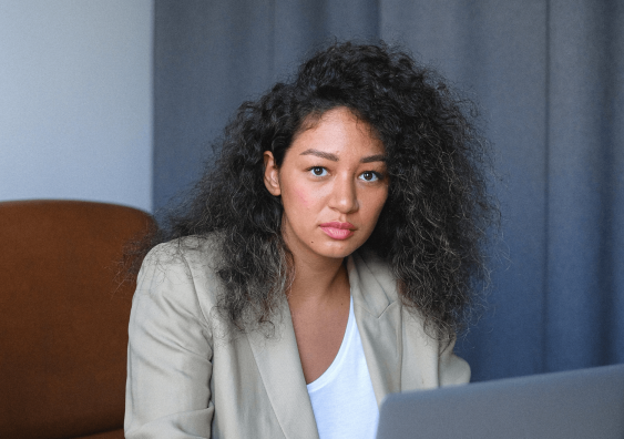 Serious young female entrepreneur working on laptop
