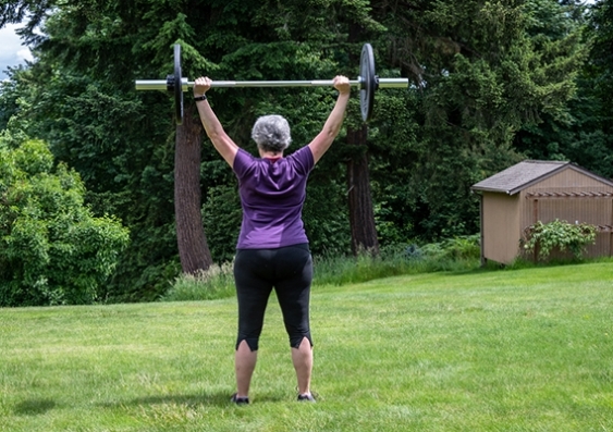 Older woman weight training in a park
