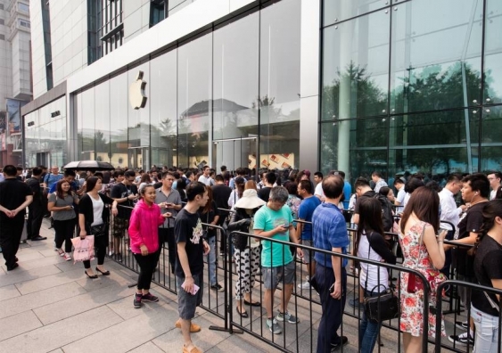 People queue outside Apple Store for the latest iPhone manufactured by cheap labour in their global supply chain