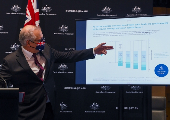 prime minister scott morrison points to modelling information at a press conference