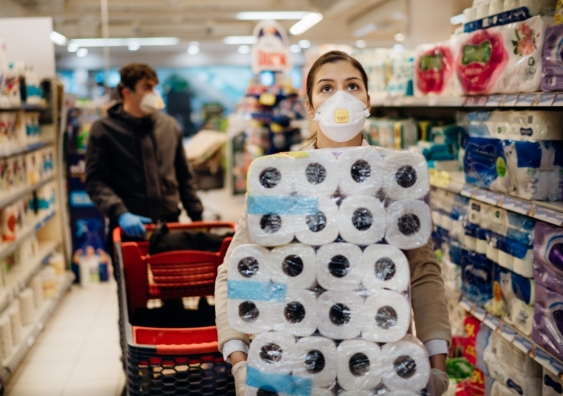 Shopper wearing protective face mask hoards toilet paper in supermarket