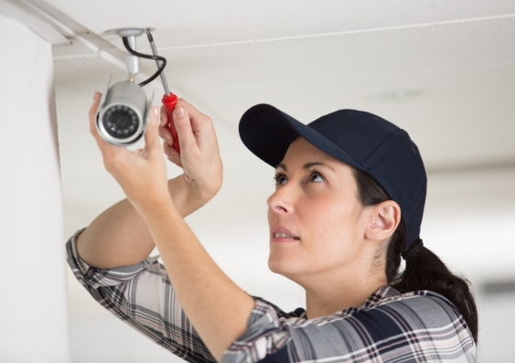 Woman installing security camera