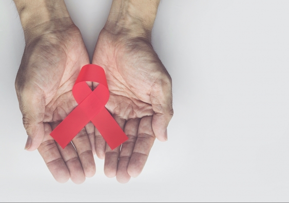 Man holding red aids ribbon, HIV/AIDS 