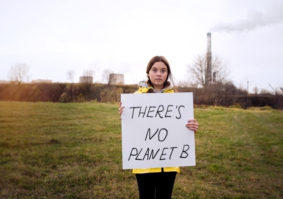 A child holding a sign saying no planet B.