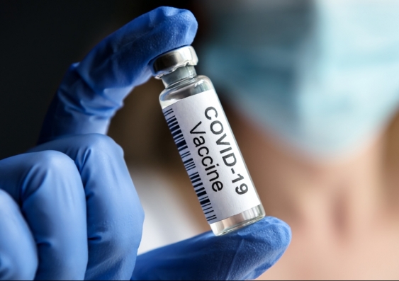 Doctor holds bottle with COVID-19 vaccine in laboratory
