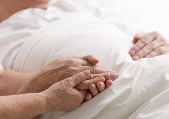 Someone holding an elderly's hands in hospital