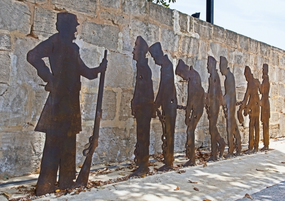 silhouettes of colonial convicts and an armed guard
