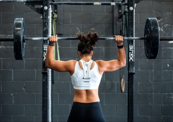 A strong-looking woman lifting weights in a gym