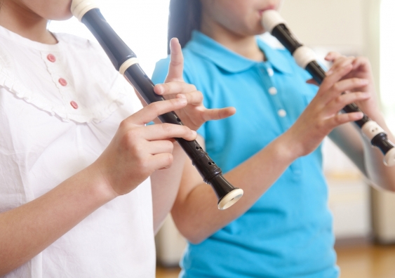Two young students playing the recorder