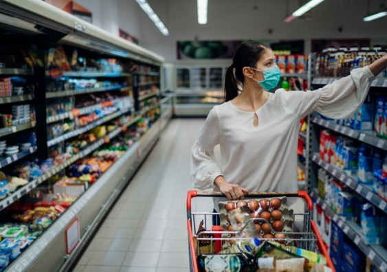 Woman shopping in supermarket wears protective face mask