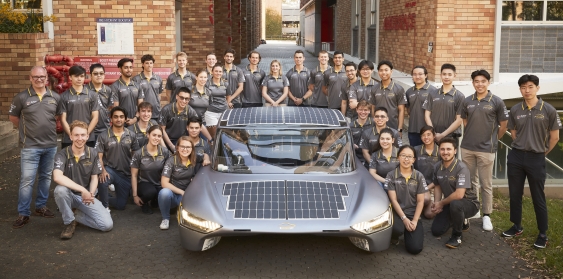 The Sunswift team pose for a photo around the latest Sunswift car