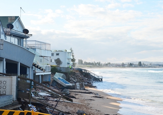 Waves draw near damaged houses at Collaroy Beach, Sydney