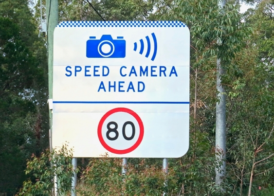 A sign showing the speed limit as being 80 and warning of a speed camera ahead