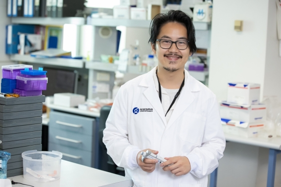 Photo of Dr Kenny Chi Kin Ip in the laboratory holding a pipette