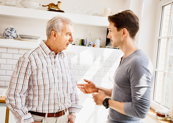 Young man talks to an older man in kitchen