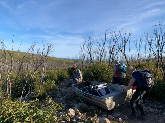Researchers hauling a boat overland to reach the platypus traps