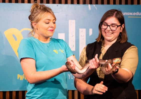 Arc organiser Courtney Cross (left) tries to ignore her fear of snakes by holding a diamond python to raise money for Phil’.