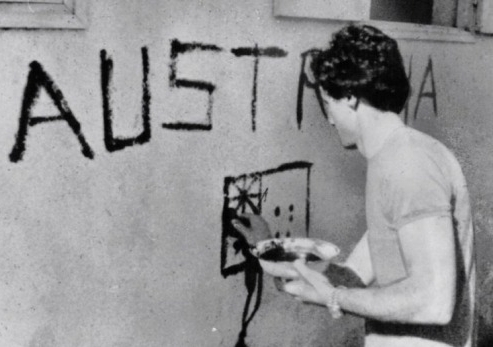 Greg Shackleton paints "Australia" on a shop wall in Balibo in East Timor in 1975. He and five other journalists were killed while covering Indonesia's invasion.