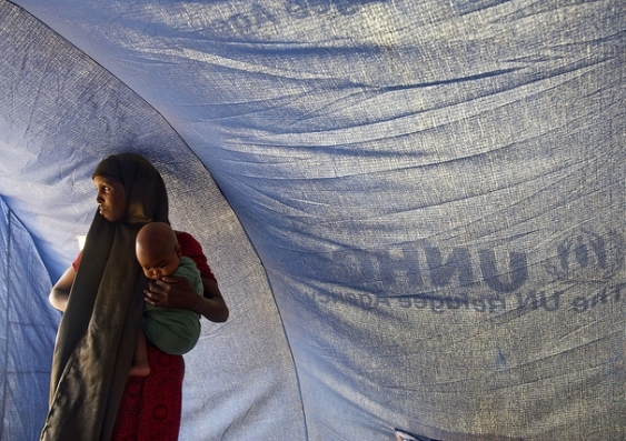 United Nations Photo. A Somali refugee stands inside a tent with her baby in Dollo Ado, Ethiopia. https://www.flickr.com/photos/un_photo/