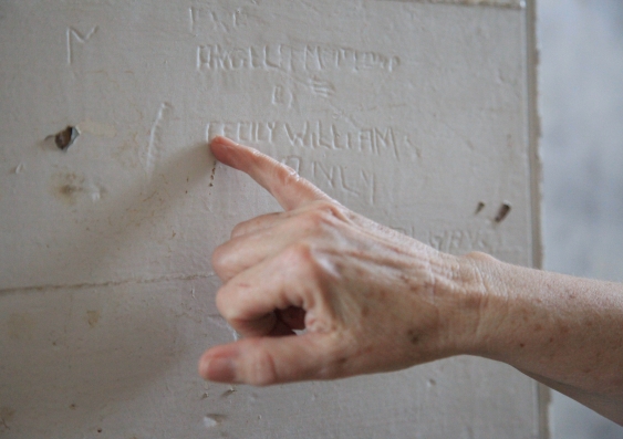 Bonney Djuric points to names of former residents scratched into Privilege Room passage wall, Parramatta Girls Home. Photo: Lily Hibberd, 2012.
