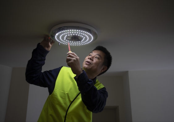 Dr Wen Hu checking one of the hallway lights meshed into the smart building network.