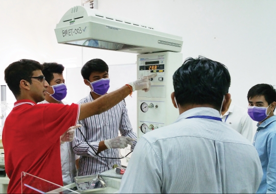 Ojasvi Chavali inspects medical equipment with his Cambodian counterparts. Photo: supplied
